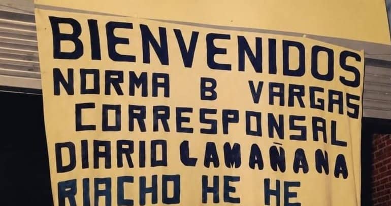 Cartel artesanal amarillo pintado a mano: Bienvenidos Norma B Vargas corresponsal Diario La Mañana Riacho He Hé.